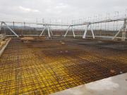 Fasádní příhradová konstrukce a připojená železobetonová deska během výstavby (© Gruner AG)