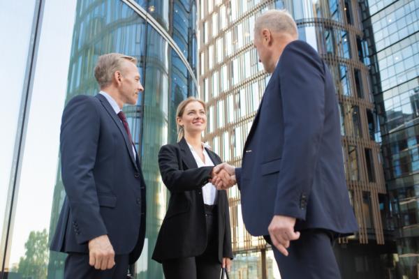 Ein engagiertes Verkaufsteam mit einem Sales Manager beim Abschluss eines Geschäftsdeals.