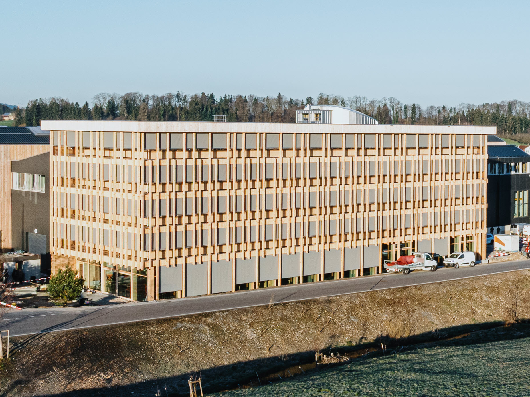 Moderní kancelářská architektura v dřevěné konstrukci s velkými okny, navržená společností Blumer Lehmann.
