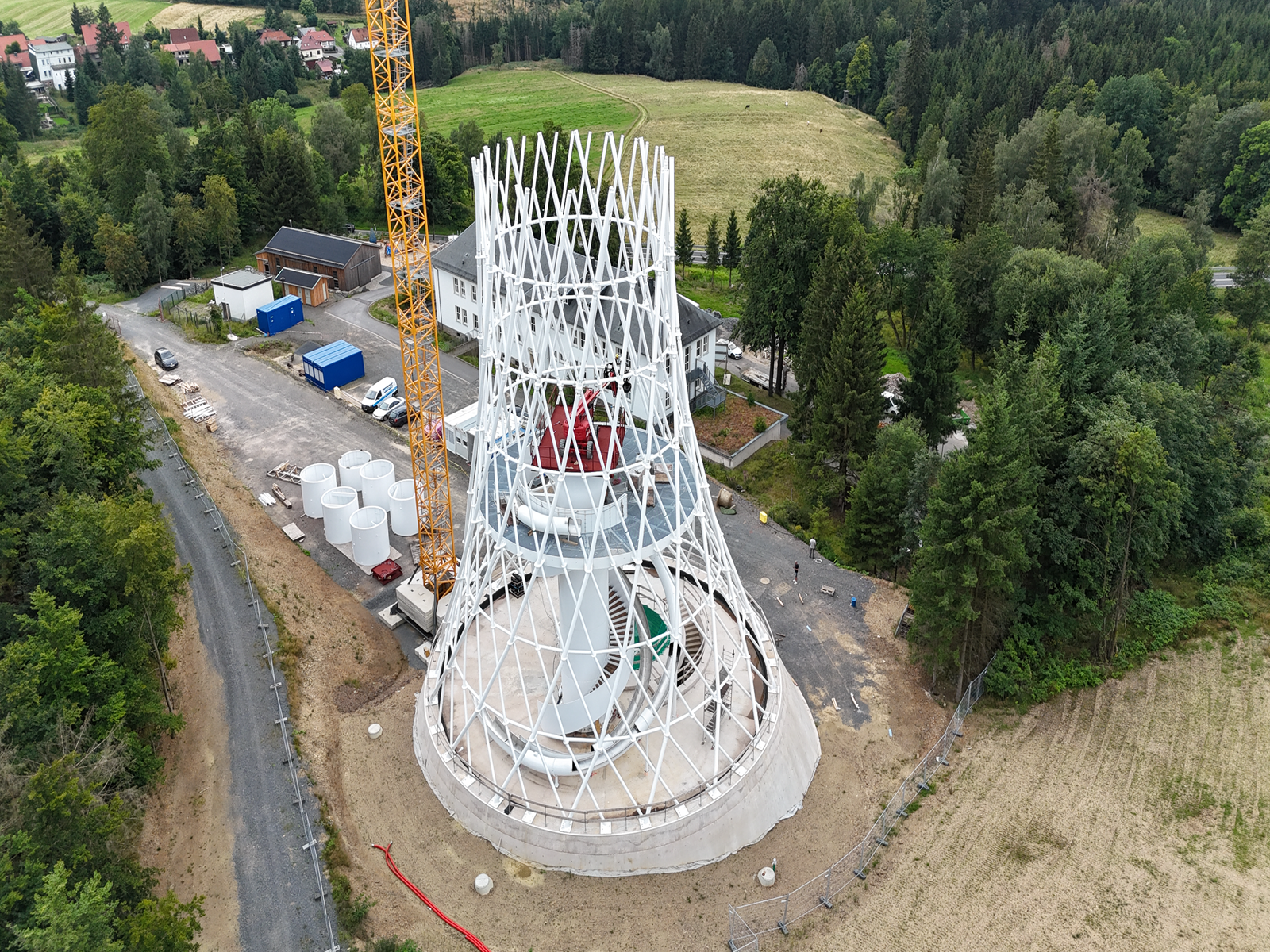 Výstavba věže Čarodějnické koště společností ibr tragwerk Barth + Rugenstein s lešením a stavebními materiály v popředí