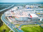 Přístavba severovýchodního rohu centra Westfield Černý Most s prosklenou fasádou a světlíkem. Ocelová konstrukce s nosníky a střechou.