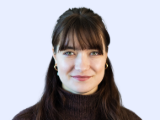 Profesionální portrét Adély, zaměstnankyně společnosti Dlubal Software, která se sebevědomě usmívá na jednobarevném pozadí.