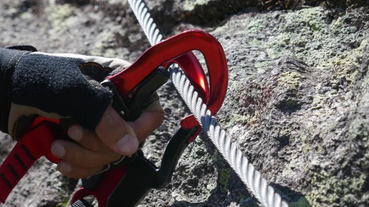 Ingenieur mit Kletterausrüstung führt Arbeiten an einem Bauwerk durch. Solche Ausrüstung ist bei Höhenarbeiten unerlässlich.