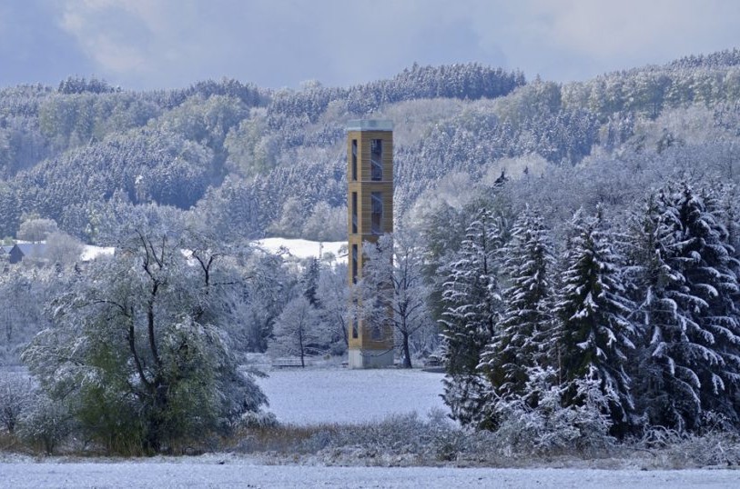 Der Bannwaldturm im Winter mit verschneiten Bäumen im Hintergrund.