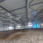 Ansicht einer Bodenplatte mit erstellter Bewehrung einer Baustelle. Die Bewehrungsstäbe sind engmaschig ausgelegt.