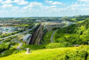 Einfahrt des Eurotunnels in einer offenen Landschaft, aufgenommen bei klarem Himmel.