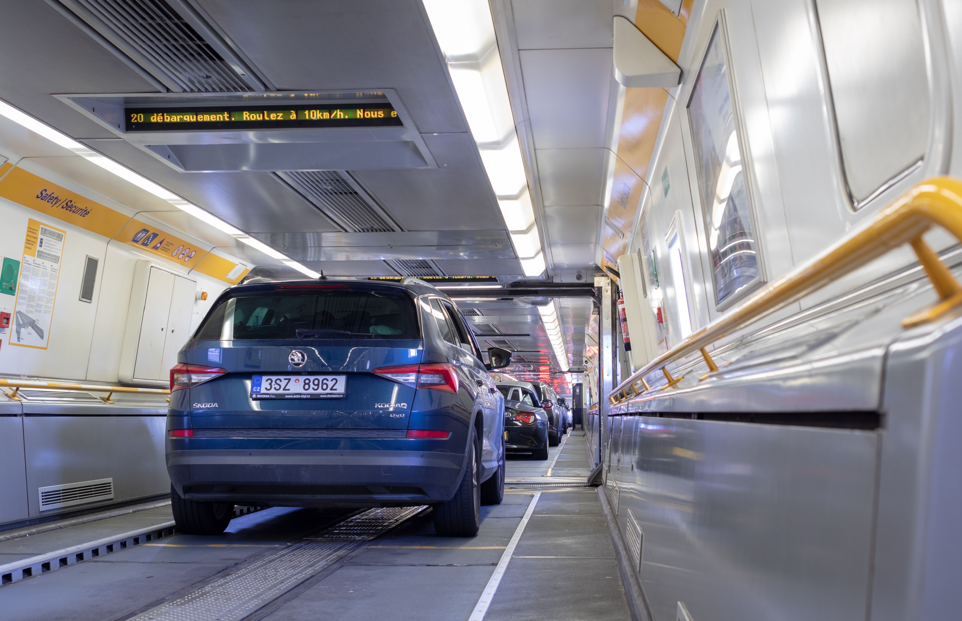 Innenansicht eines Eurotunnel-Shuttlezuges mit Fahrzeugen auf engstem Raum.