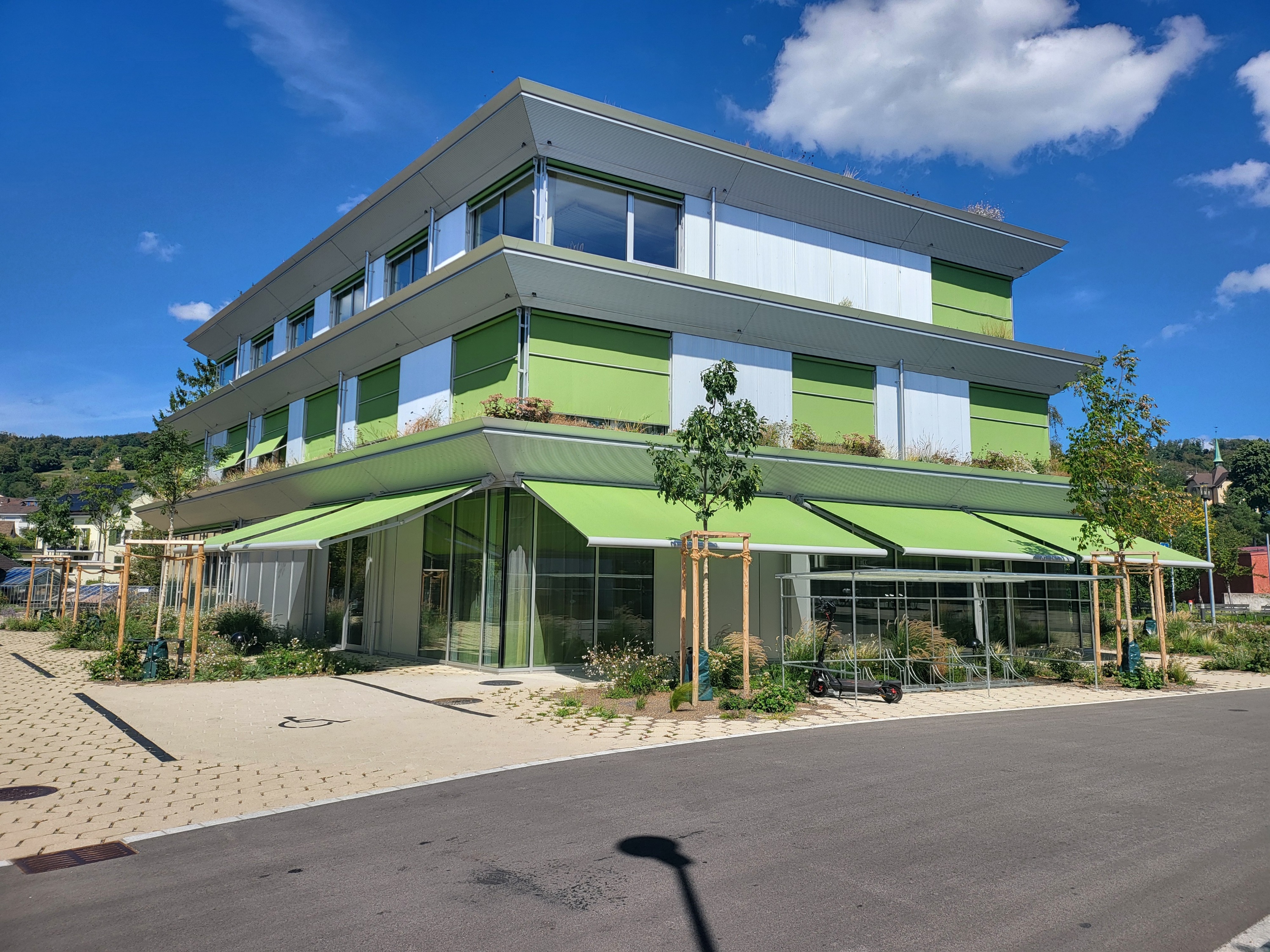Mehrgeschossiges Wohn- und Geschäftshaus in Uetikon am See mit hellem Metallschalungsfassade und großflächigen Fensterbändern