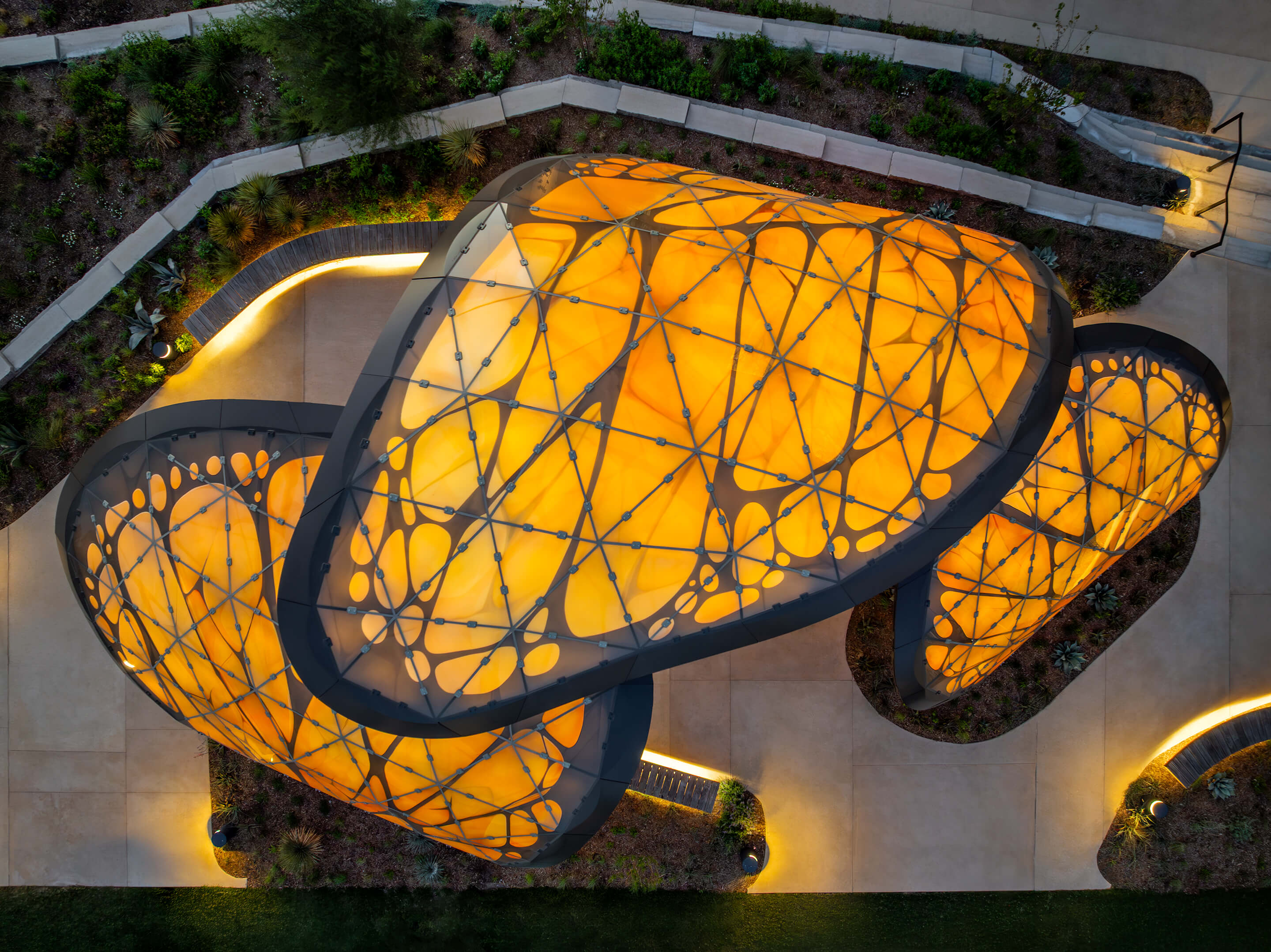 Aerial view of the organically shaped steel canopy “The Monarch San Antonio” in Texas, USA, featuring an illuminated roof structure.