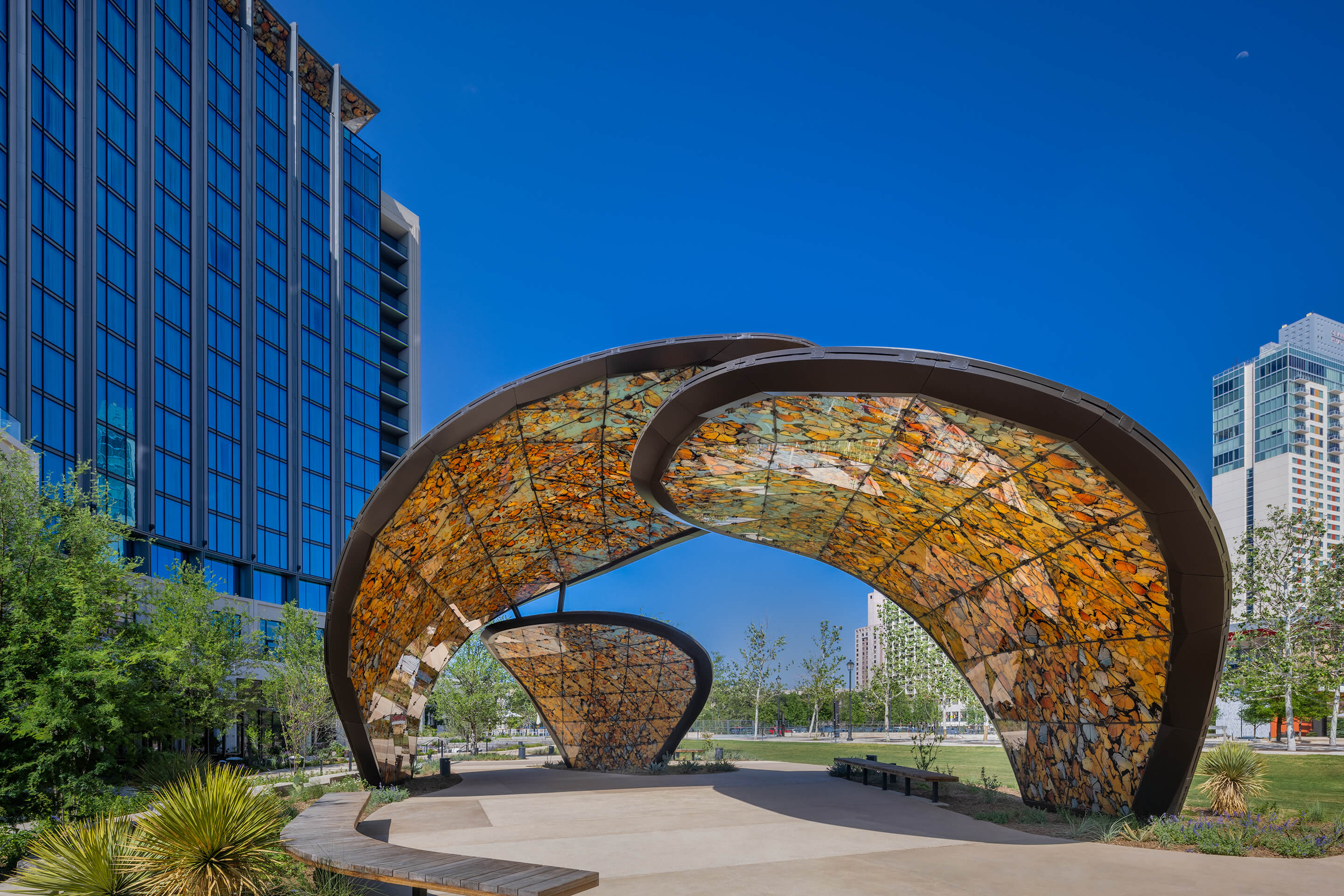 View of the striking steel canopy “The Monarch San Antonio” in front of a modern building in Texas, USA.