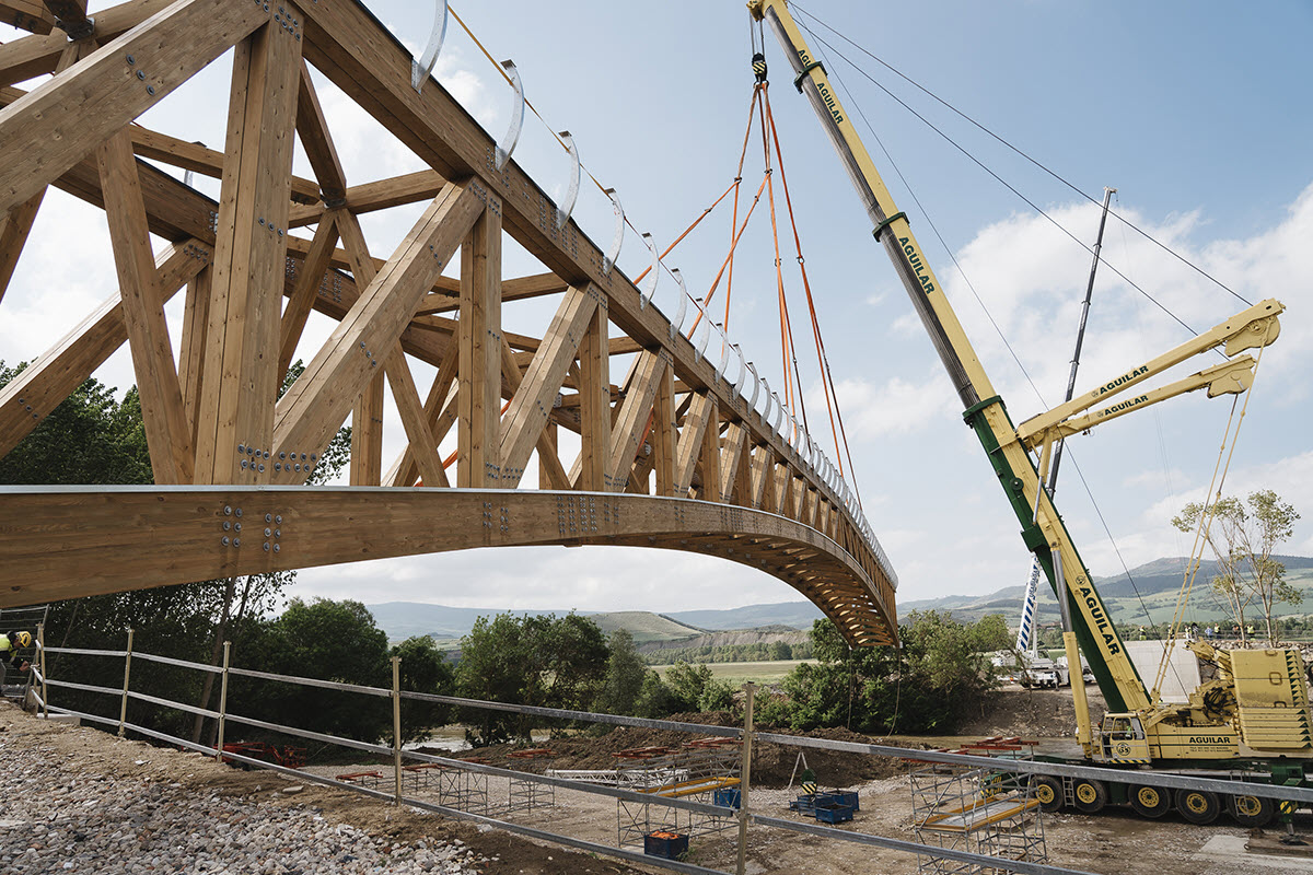 Pasarela de madera siendo instalada. Proyecto notable de construcción en madera con diseño estructural avanzado.