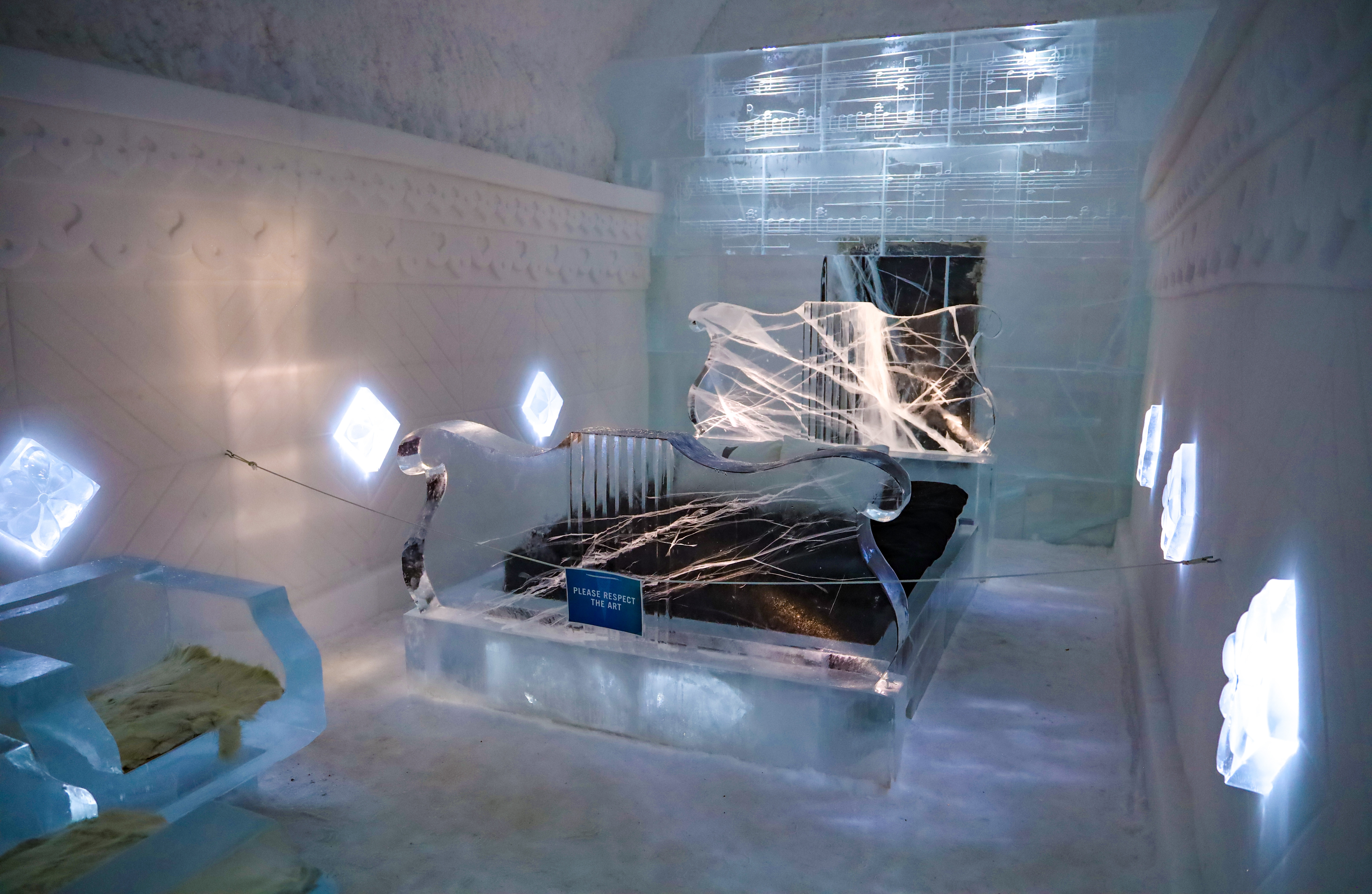 Vista interior de una habitación de hotel con temática musical en el Hôtel de Glace de Laponia, Suecia. Diseño del espacio inspirado en elementos musicales, iluminado con luz tenue.