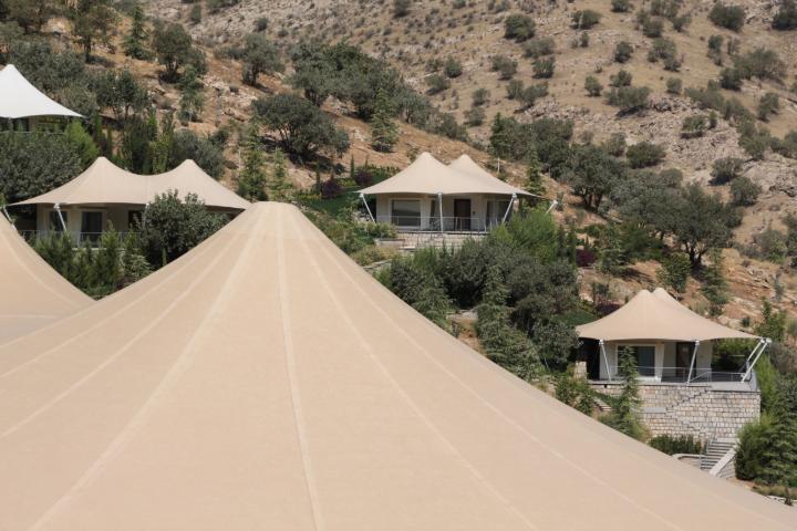 Cubierta de membrana en terreno montañoso; arquitectura moderna en armonía con el entorno natural.