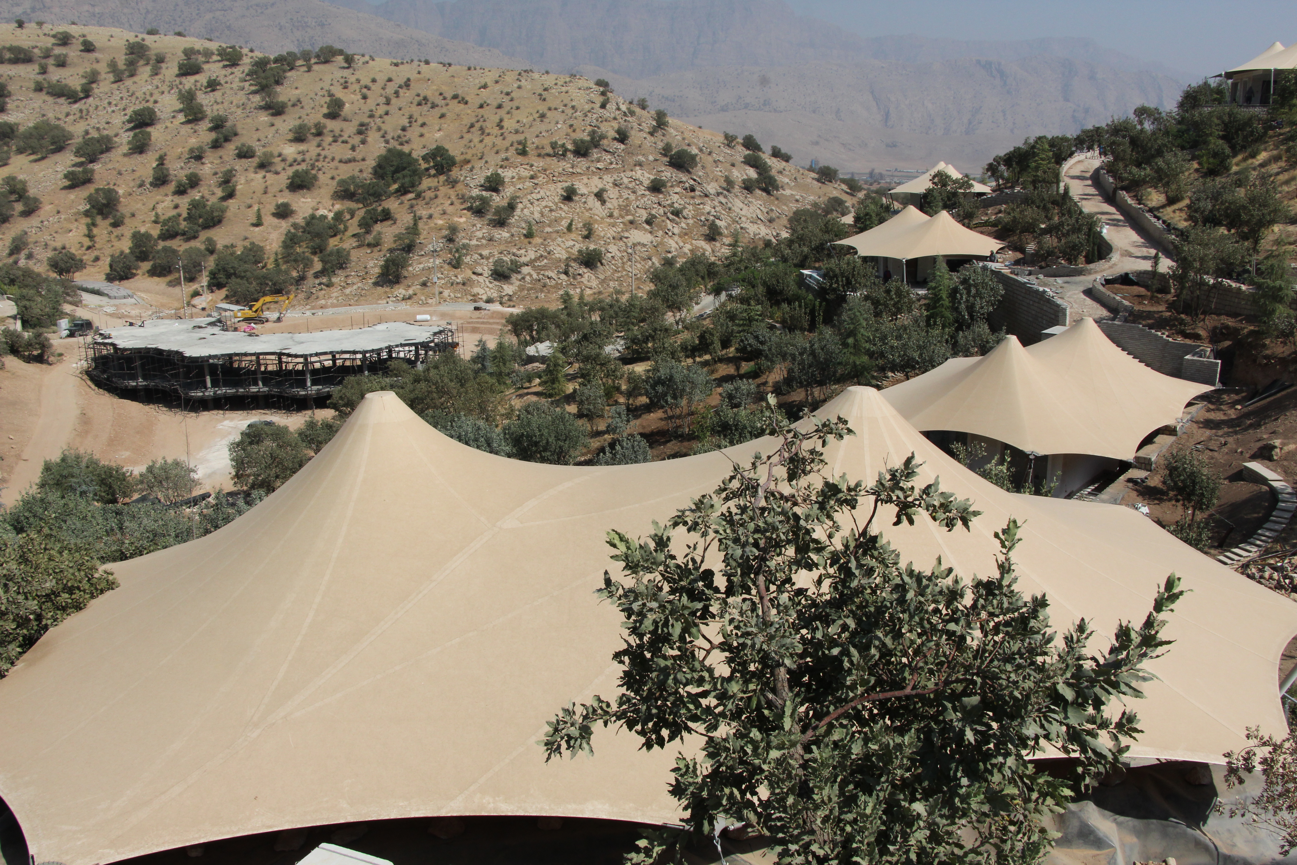 Cubiertas de membrana en el campamento Armoon de Savana General Trading bajo un cielo azul con sol de fondo