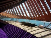 Vista detallada de la estructura arquitectónica bajo las icónicas velas del Sydney Opera House.