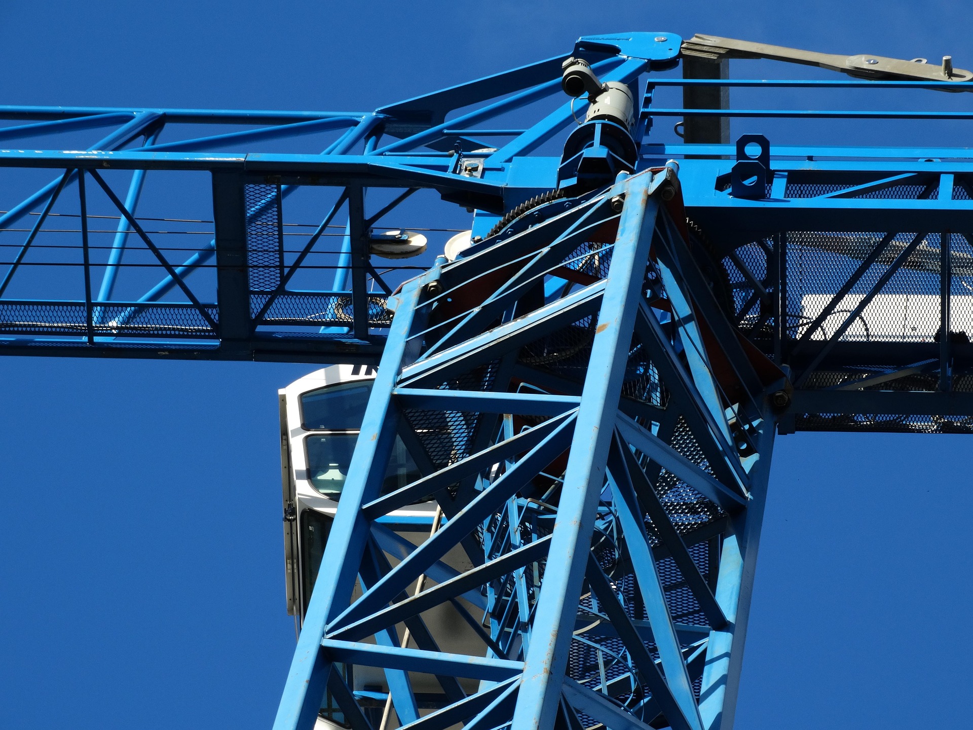 Grúa azul de celosía en una obra, lista para trabajos de construcción.