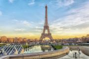La tour Eiffel, symbole de Paris, s'élève imposante dans le ciel. Une vue rapprochée montre les détails de la structure.
