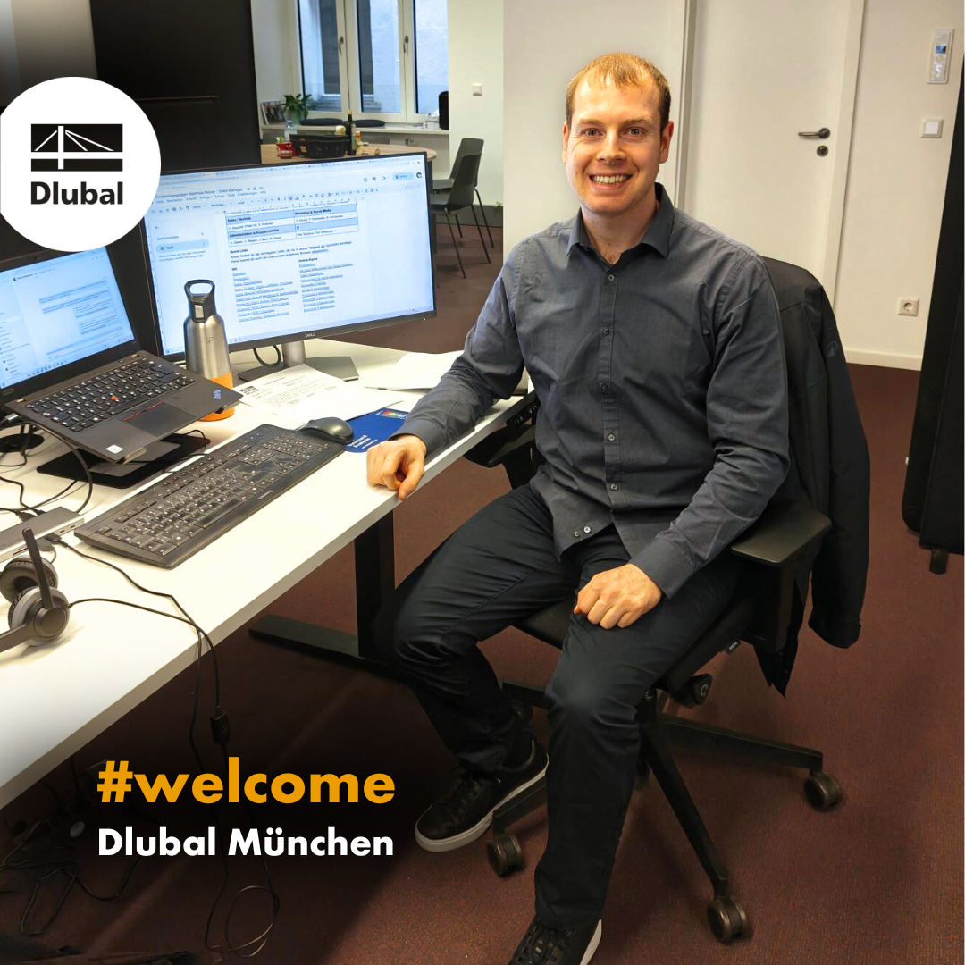 Nouvelle employée souriante à son bureau dans les locaux de Dlubal à Munich