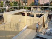 Chantier de construction d’un immeuble de 6 étages en CLT à Modène, Italie, montrant des éléments structurels et le cadre