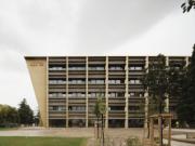 Vue latérale d’un bâtiment universitaire en bois avec une architecture moderne et durable, projet architectural innovant