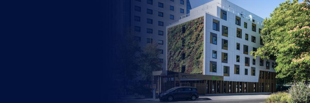Façade moderne de l'Hôtel Mercure Paris Porte de Pantin, située en périphérie de Paris, avec structures en verre et béton.