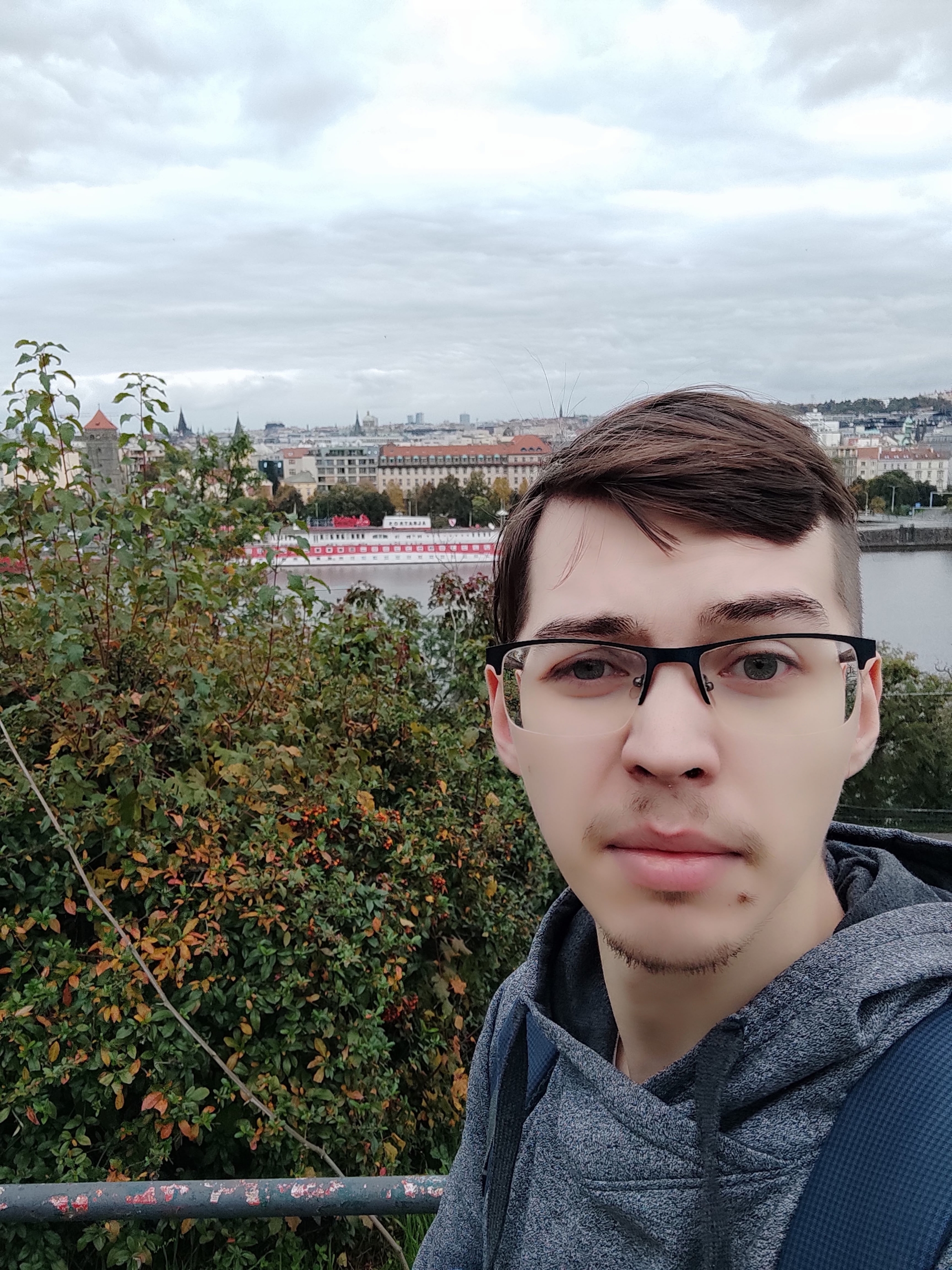 Ivan Maltsev, nouveau membre de l'équipe IA de Dlubal Software, en extérieur avec un paysage urbain en arrière-plan.