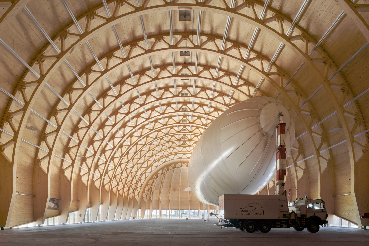 Hangar sostenibile per dirigibili a Mühlheim con struttura portante in legno e fondazioni riciclate, naturalmente illuminato