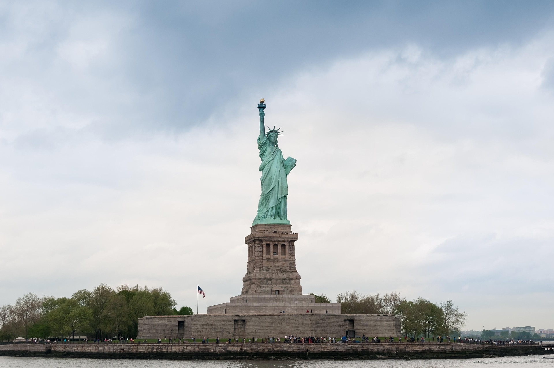 Statua della Libertà a New York con cielo azzurro sullo sfondo, simbolo di libertà e democrazia.