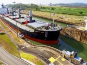 Una nave portacontainer attraversa il canale di Panama durante il giorno.