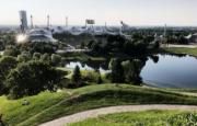 Viene rappresentato l’ambiente artificiale creato attorno allo Stadio Olimpico di Monaco di Baviera. Sono visibili elementi architettonici e aree verdi.