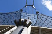 Vista dettagliata della struttura del tetto dello Stadio Olimpico di Monaco, mostra un’architettura innovativa con cavi di tensione e membrane tese.
