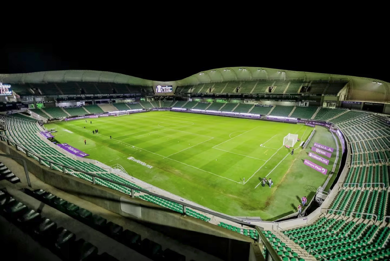 Nocne zdjęcie imponującego stadionu z jasnym oświetleniem podkreślającym jego konstrukcję