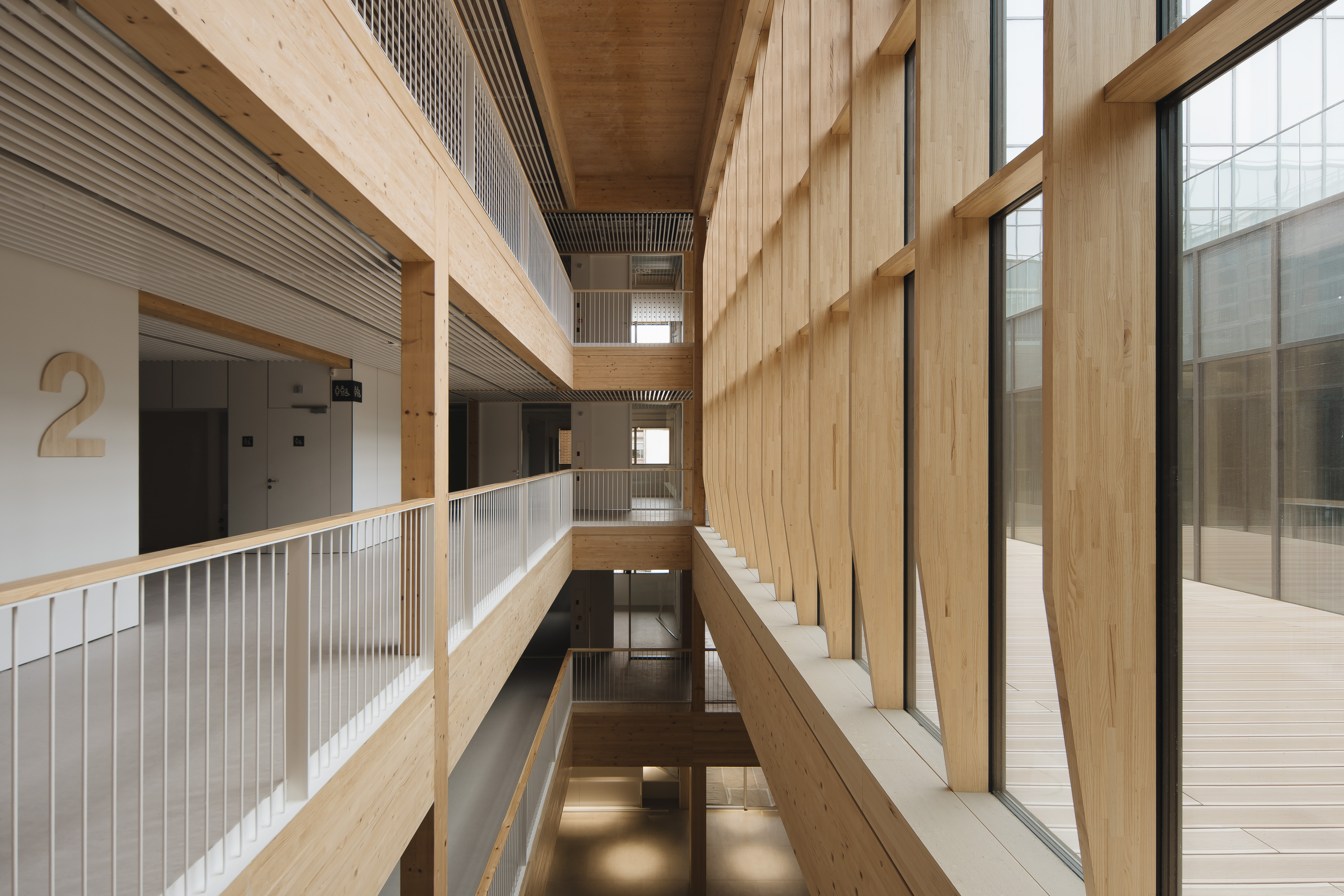 Wnętrze UPNA z nowoczesnym designem, przestrzeń typu atrium, poziomy z korytarzami i dużymi oknami.