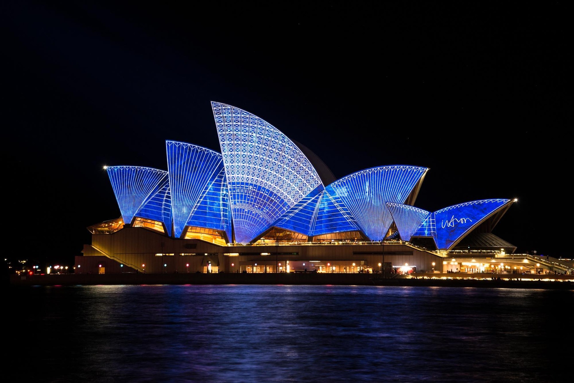 Oświetlenie konstrukcji architektonicznej Sydney Opera House nocą.