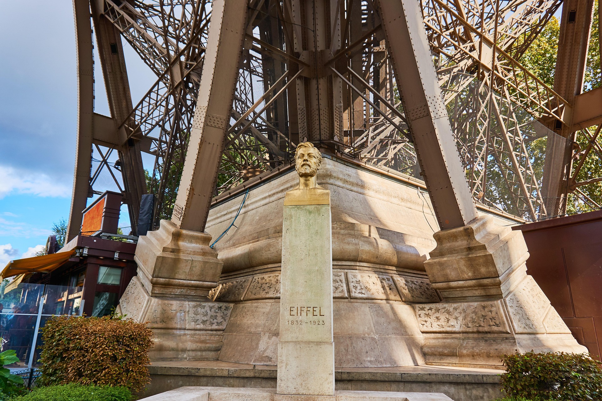 Busto de Gustave Eiffel em frente à icónica Torre Eiffel em Paris, França.