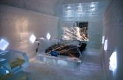 Vista interior de um quarto de hotel com tema musical no Icehotel na Lapónia, Suécia. Design do espaço inspirado em elementos musicais, iluminado com luz suave.