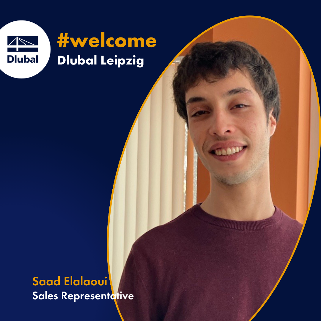 Saad Elalaoui, representante de vendas da Dlubal Software, de pé num ambiente de escritório moderno, sorrindo para a câmara