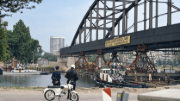 Ponte em arco de aço içada sobre apoios provisórios durante o seu translado através do Canal de Amesterdão-Reno