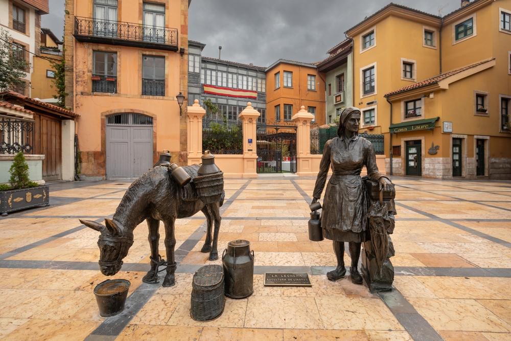 Скульптура Молочницы на площади Пласа Траскорралес в Овьедо, окруженная типичными зданиями