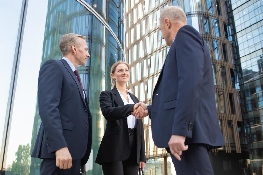 Ein engagiertes Verkaufsteam mit einem Sales Manager beim Abschluss eines Geschäftsdeals.